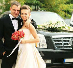 Newly wed couple standing in front of a limousine for their special occasion