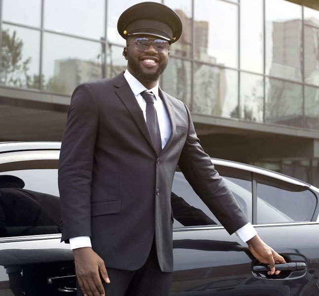 a black man standing in front of a limousine for pick-up and drop-off