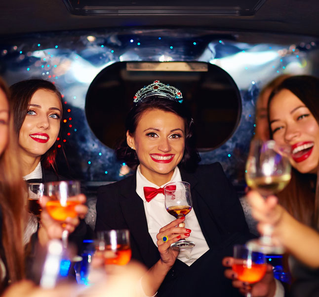 Girls drining and partying in a luxurious limousine after prom